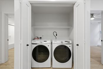 Two front loading machines in laundry room 1